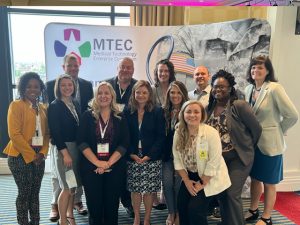 Photo of some of the MTEC and MRDC team in front of the MTEC booth at the 7th Annual Meeting.